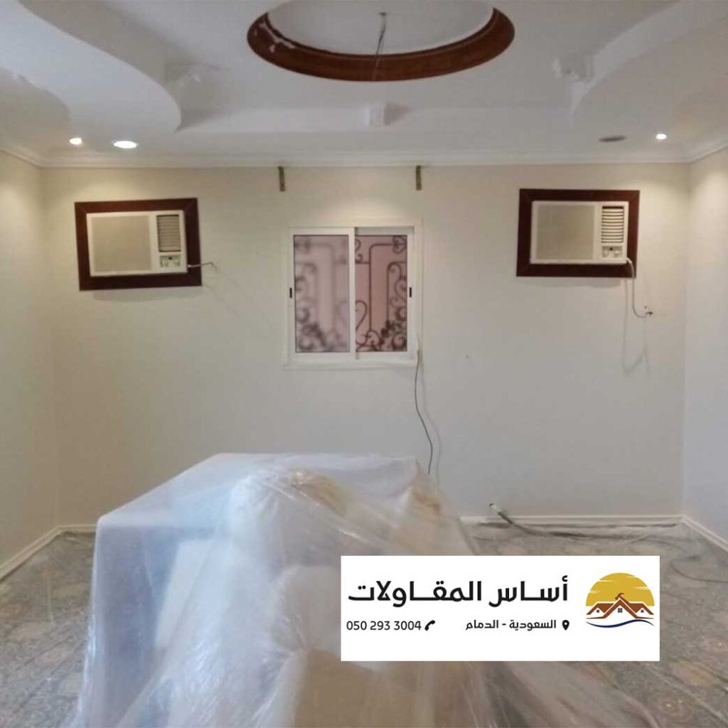 صورة لغرفة نوم صغيرة مطلية باللون الأبيض الساطع.